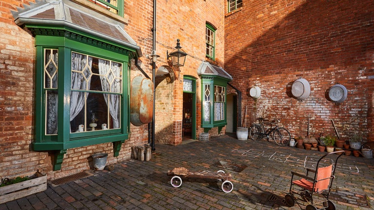 Toys and domestic items of day to day living on the courtyard of Court 15 at Birmingham Back to Backs, West Midlands